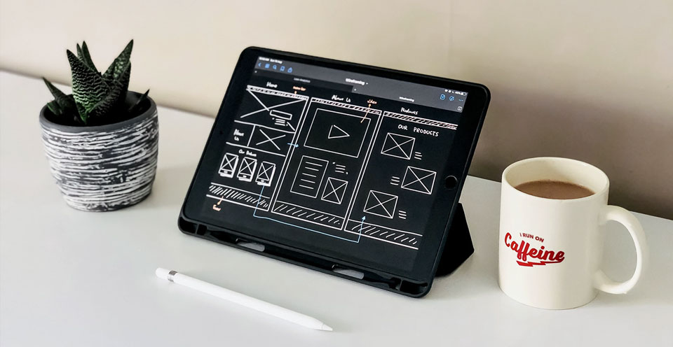 Divi Tutorial - Ein Website Wireframe auf einem Tablet neben einer Kaffeetasse und einem Kaktus